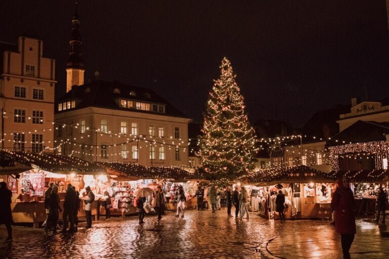 crowd walking in front of building near Christmas tree